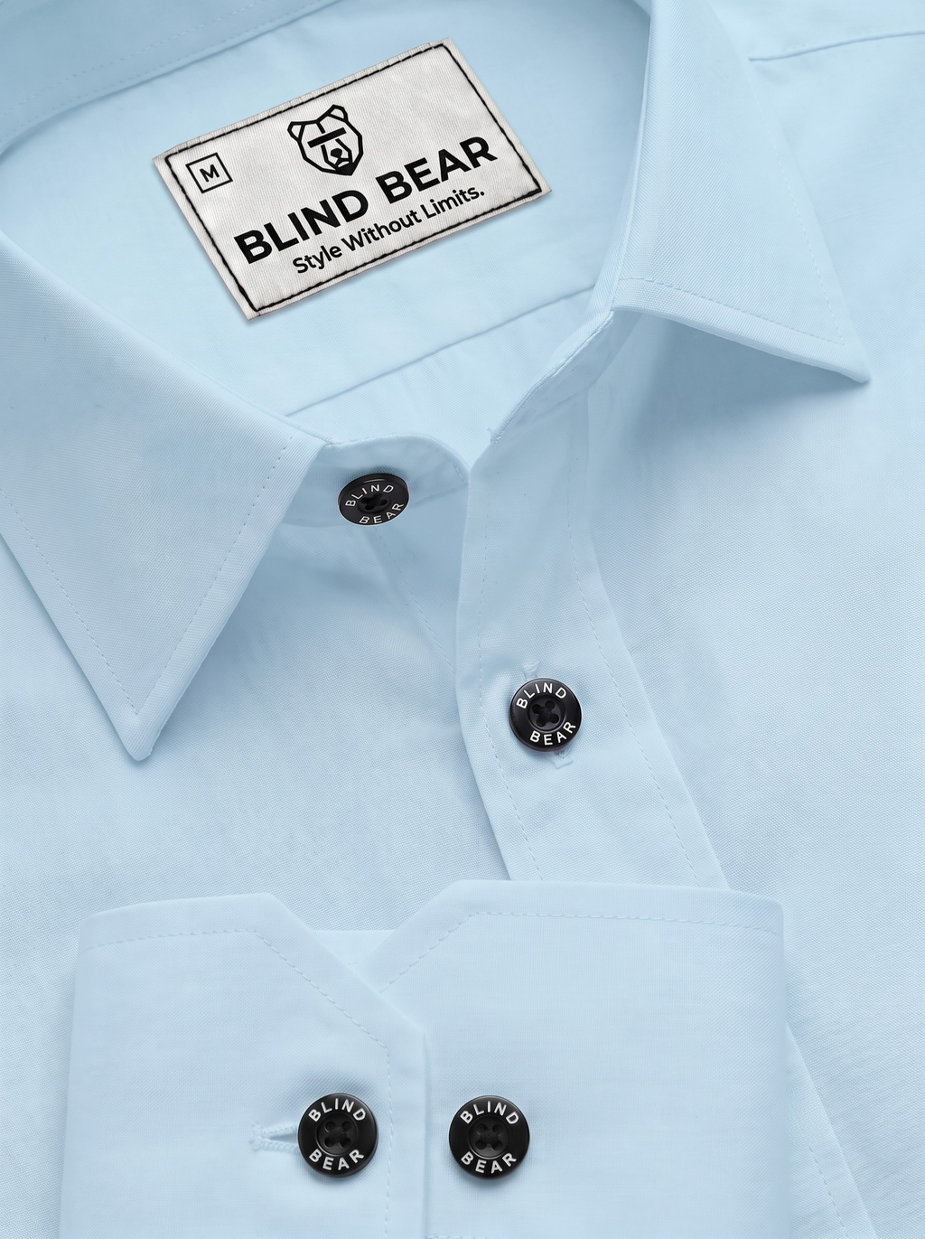 Close-up of a light blue dress shirt with a visible Blind Bear neck label and dark round buttons on the collar and placket.